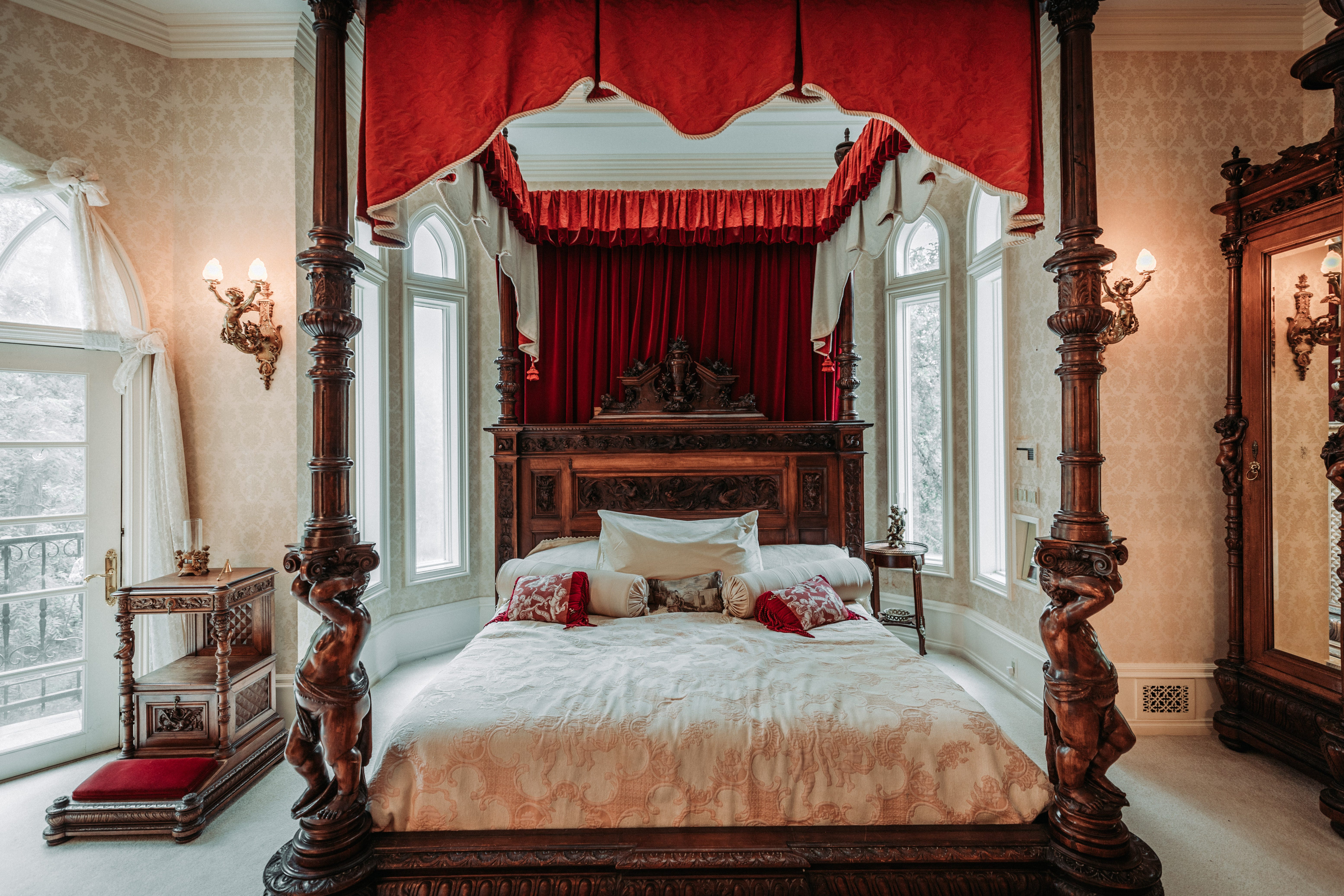 Ein Himmelbett mit roten Details befindet sich in einem der Schlafzimmer im Schloss LeBlanc.