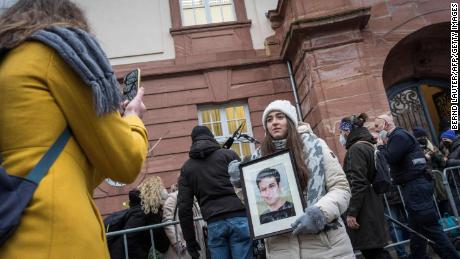 Die syrische Aktivistin Samaa Mahmoud zeigt ein Bild ihres Onkels Hayan Mahmoud, während sie und andere am Donnerstag vor dem Gerichtsgebäude in Koblenz warten.