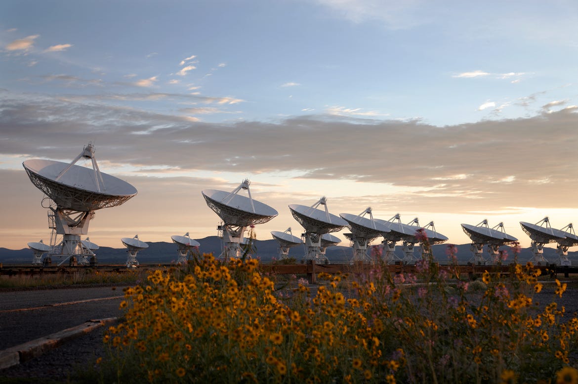 Sehr große Anordnung von etwa einem Dutzend Teleskop-Funkschüsseln, die in der Wüste aufgereiht sind