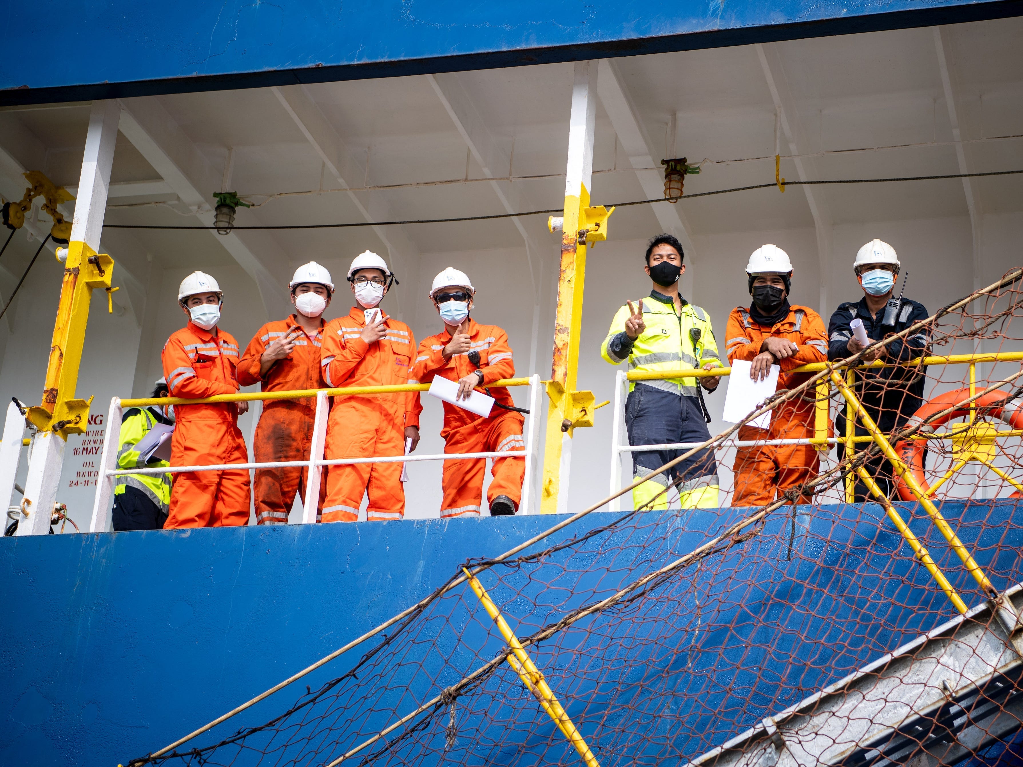 Seeleute mit Gesichtsmasken an Bord eines Schiffes.
