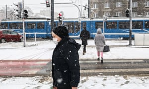 Eine Frau geht am 17. Januar in Krakau, Polen, im Schneefall spazieren, als der Gesundheitsminister des Landes warnt, dass die Omicron-Variante die täglichen Fallzahlen in die Höhe schnellen lassen könnte.