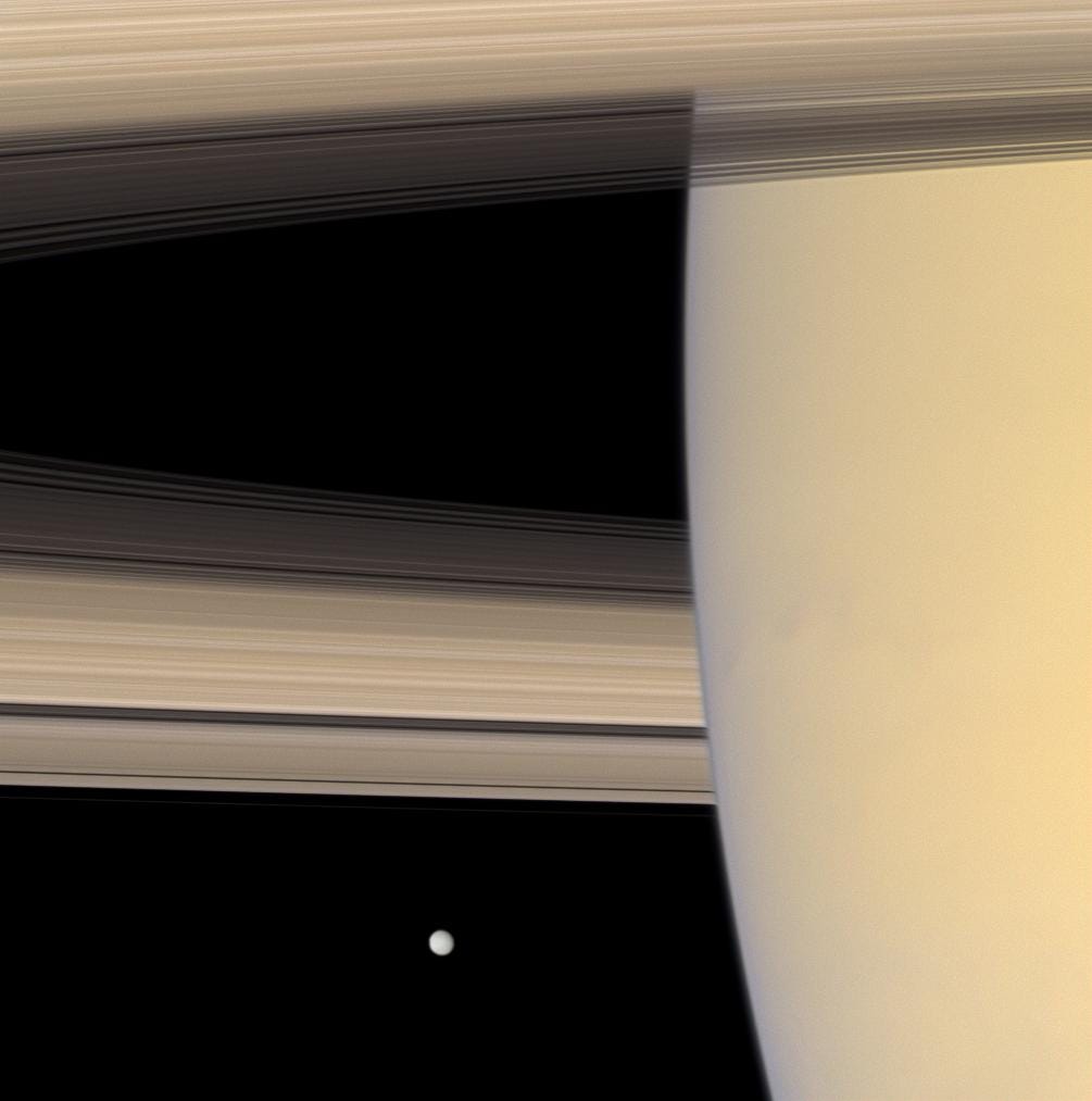 Saturnringe aus nächster Nähe mit entfernten Mondmimas im Hintergrund
