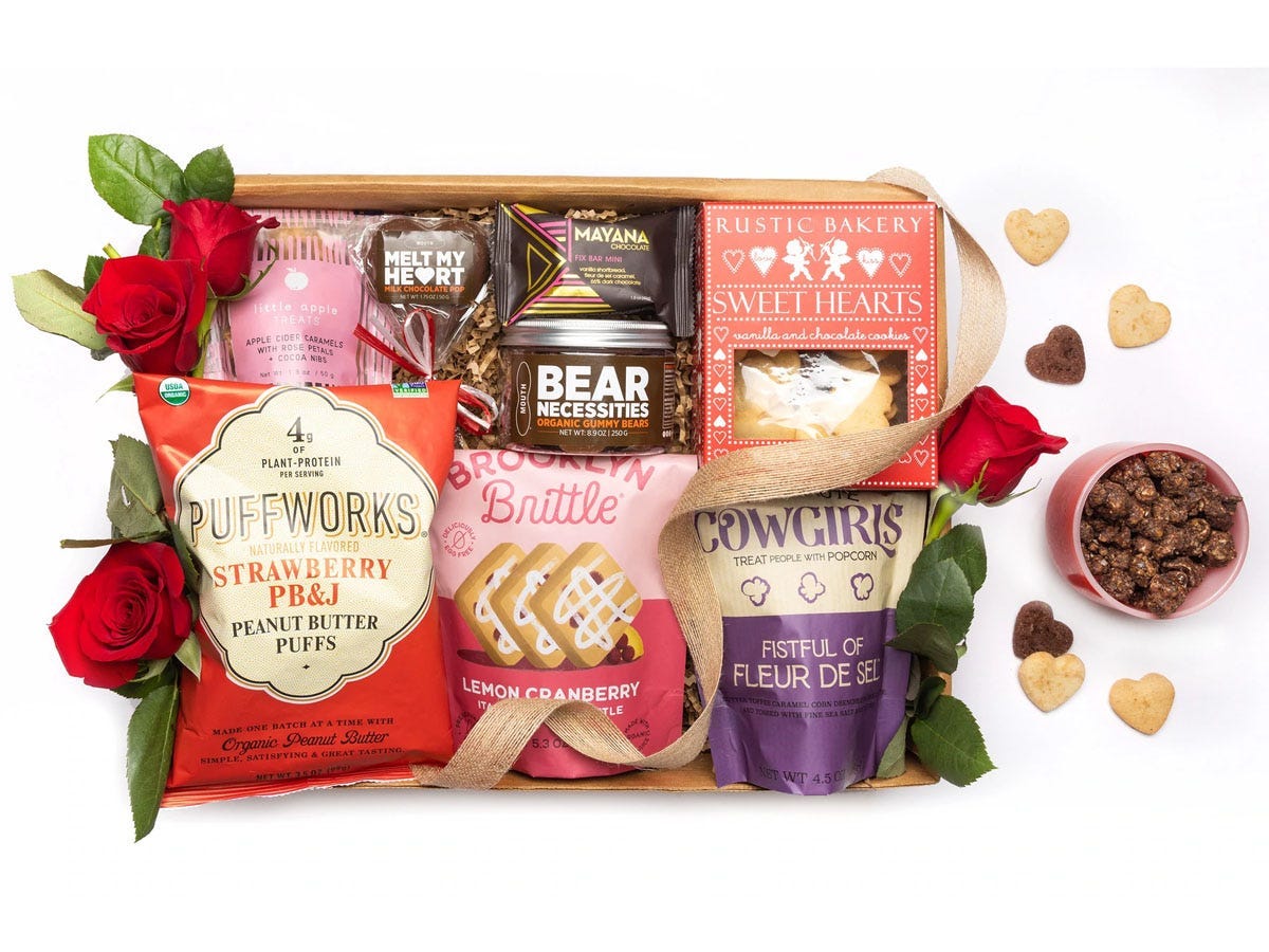 Eine Snackbox zum Valentinstag, gefüllt mit verschiedenen Chips, Popcorn und süßen Snacks