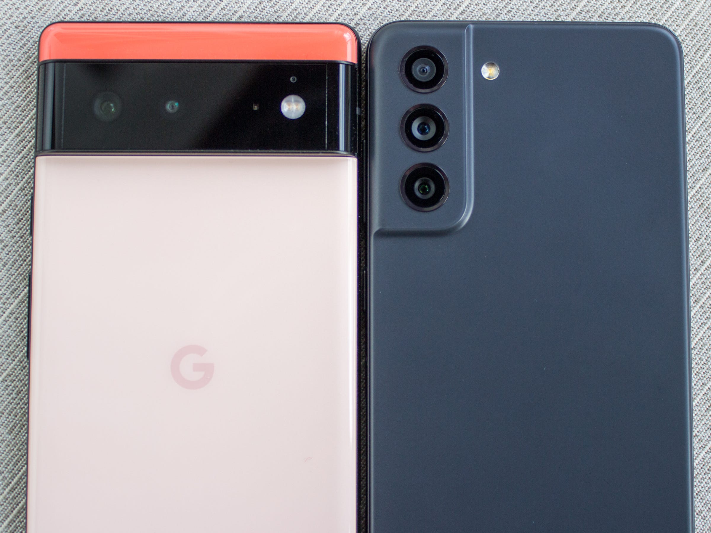 Rückseiten des Samsung Galaxy S21 FE in Graphit und des Google Pixel 6 in Koralle