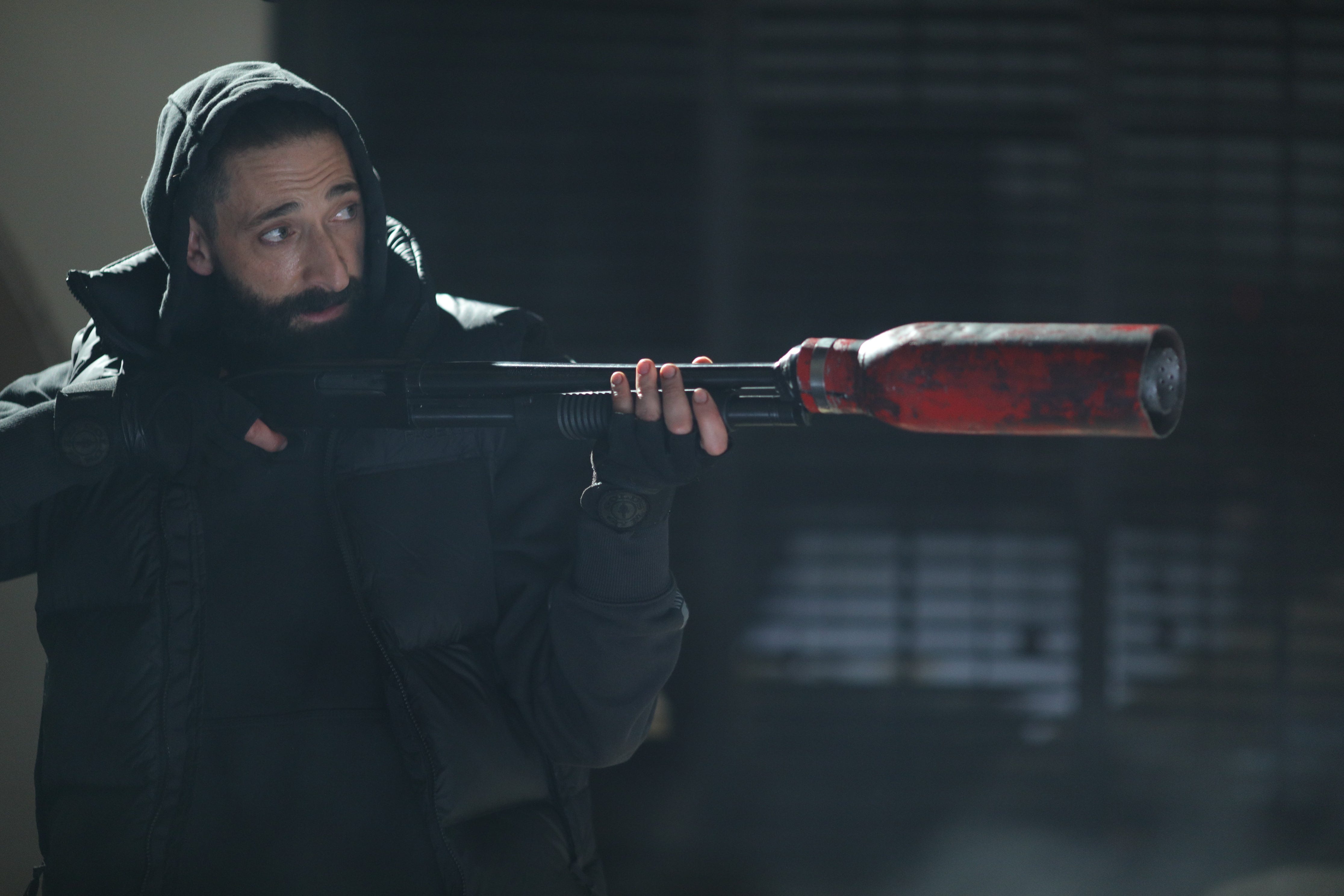 Adrien Brody hält eine Waffe in der Hand