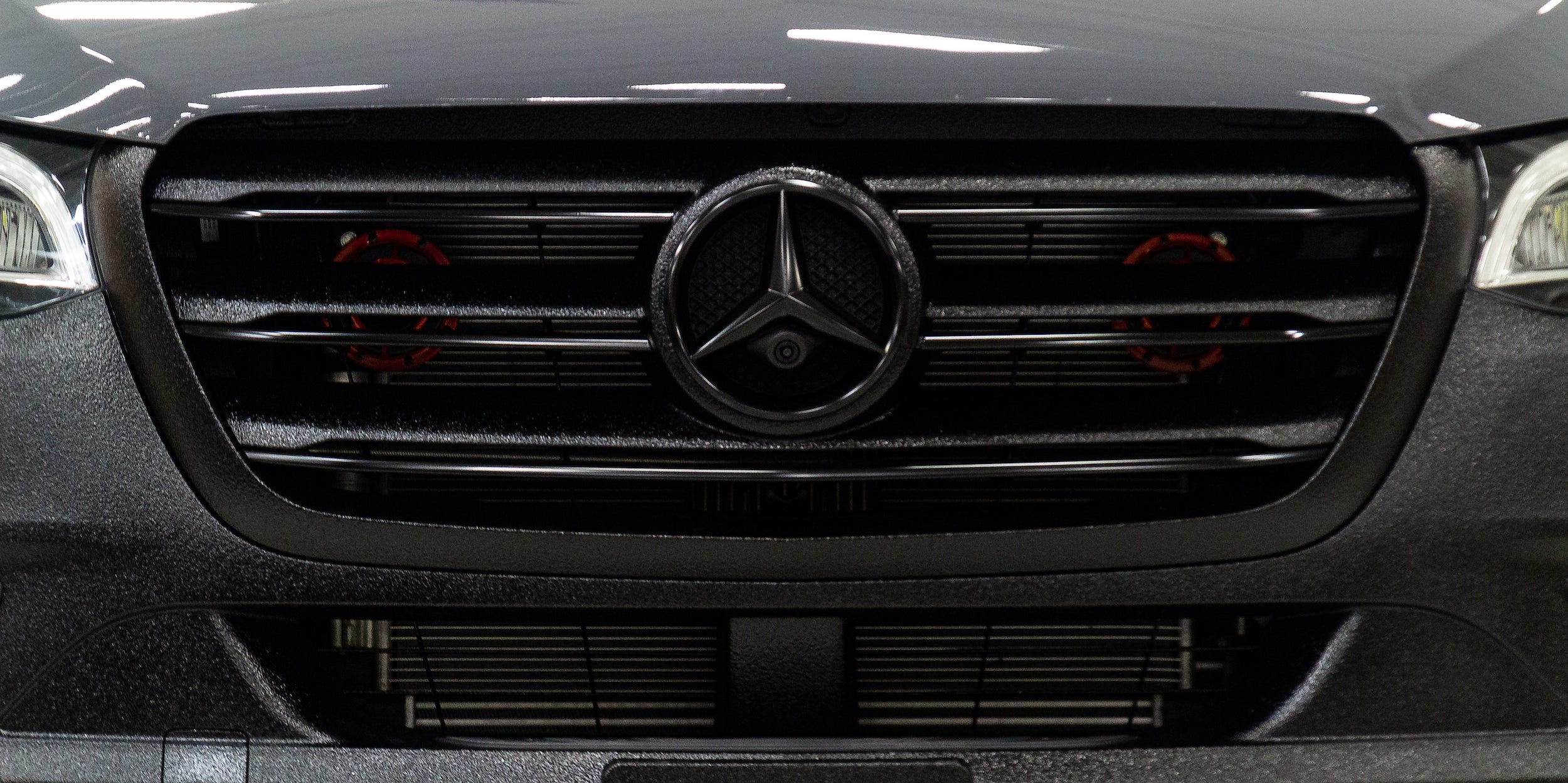 Eine Nahaufnahme der Vorderseite des Mercedes-Benz-Logos von Nelson Camper Van.