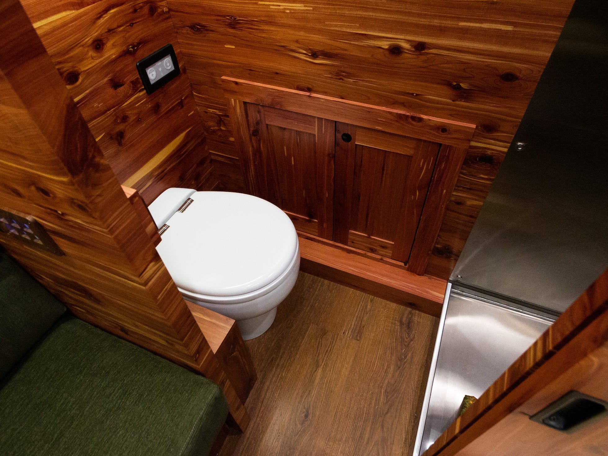 Der Fuß der Dusche und Toilette aus Edelstahl umgab den mit Holz ausgekleideten Innenraum.