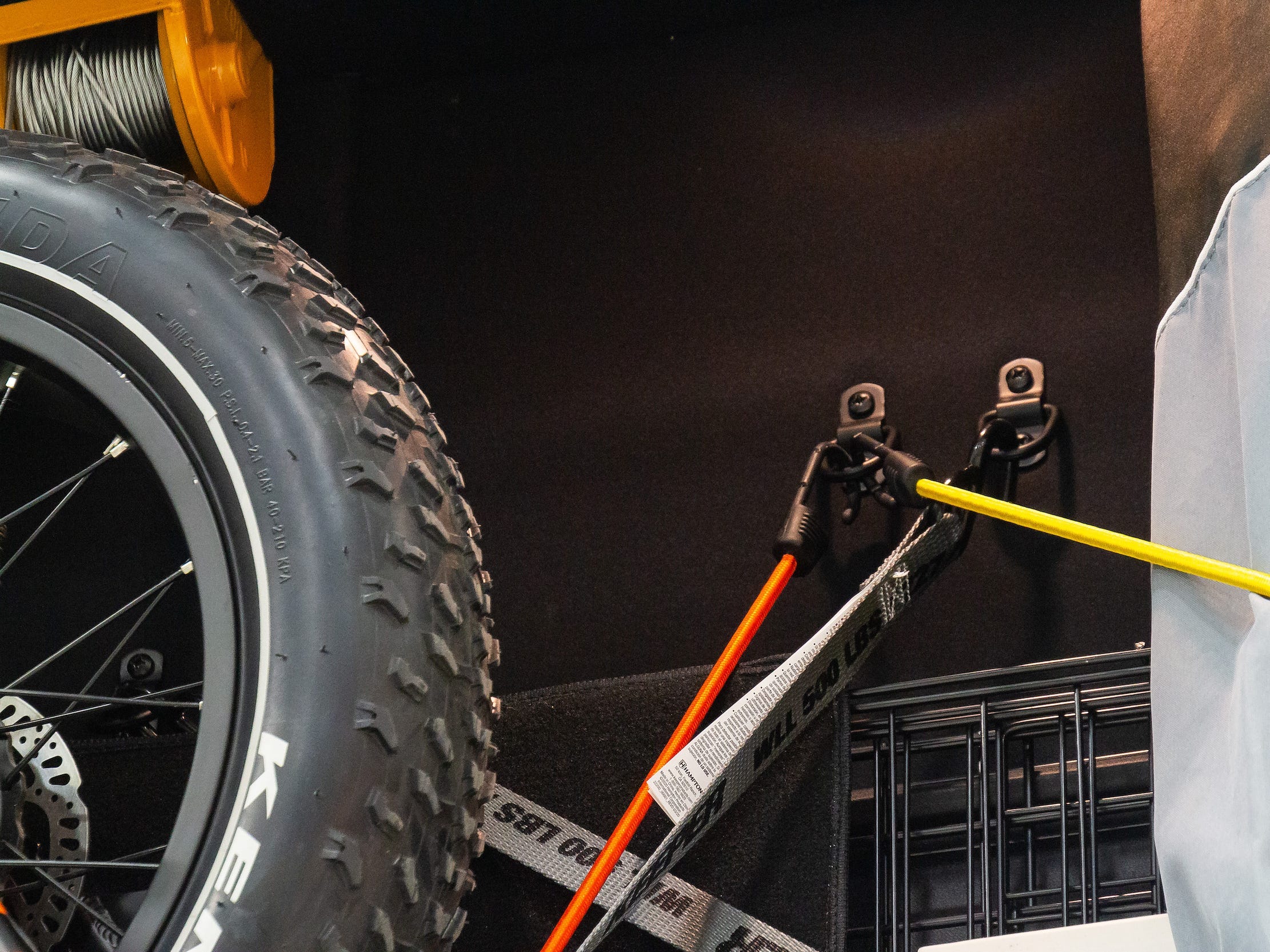 Eine Nahaufnahme der Haken und Schnüre, mit denen das E-Bike in der Garage befestigt wird.