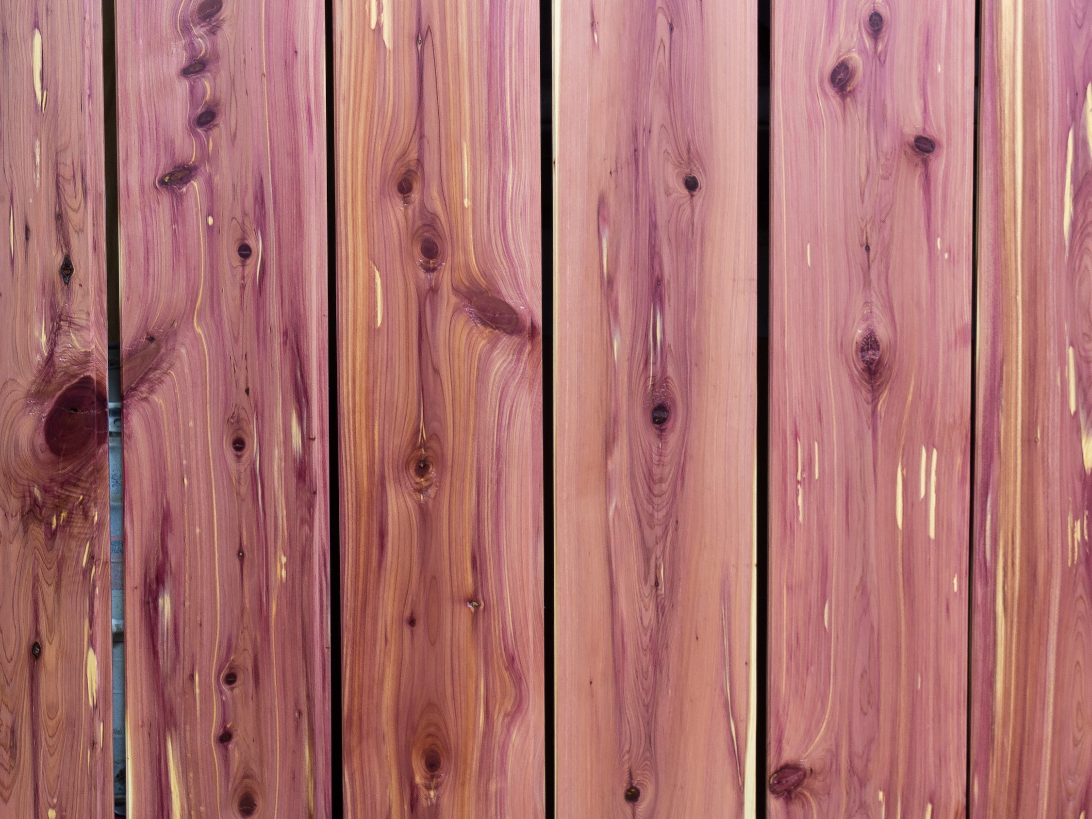 Reihen von Zedernholzplanken.  Das Holz ist leicht rosa.