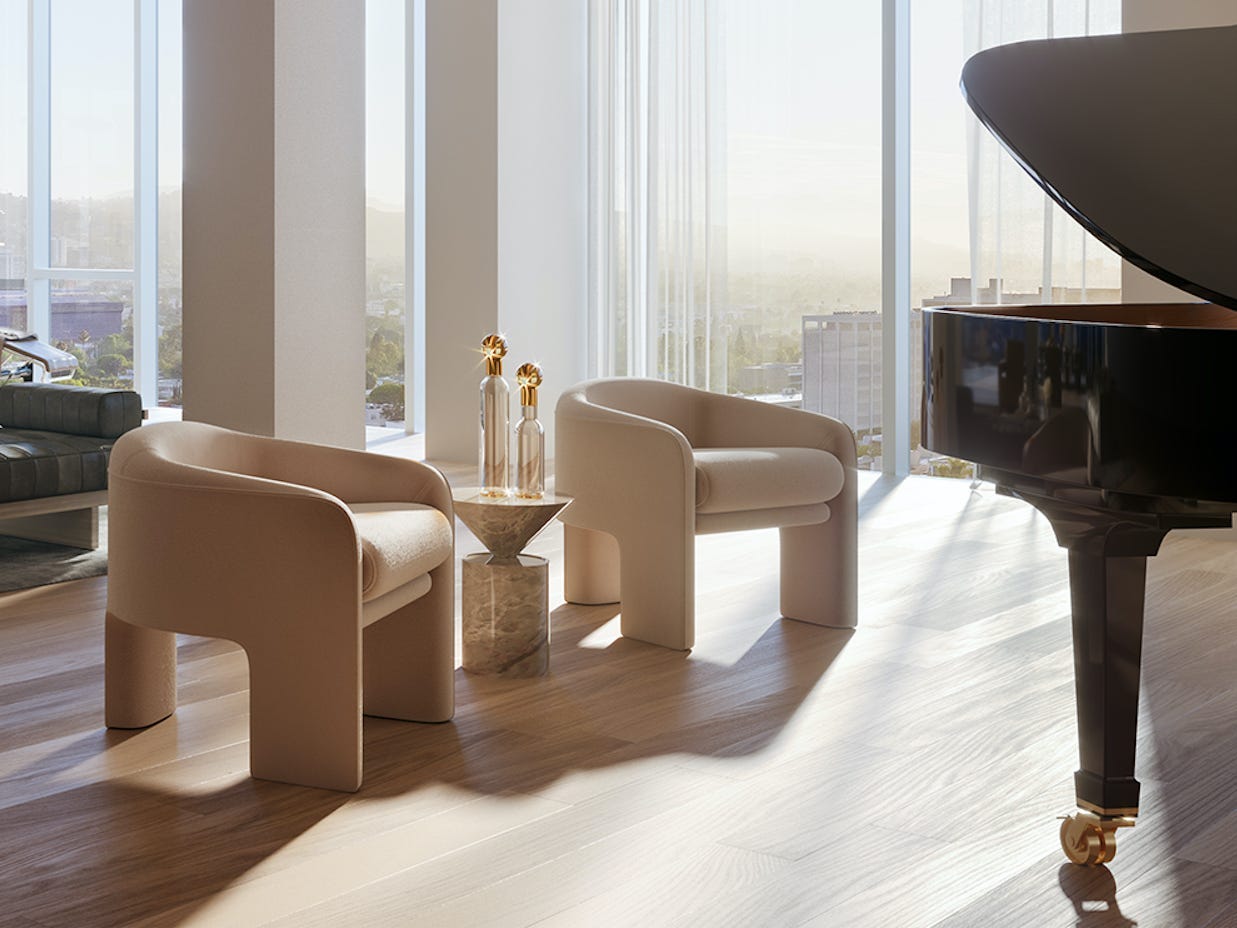 Ein Raum mit Sitzgelegenheiten, einem Klavier, einem Loungesessel und einem Tisch im hinteren Bereich mit Blick auf Los Angeles.