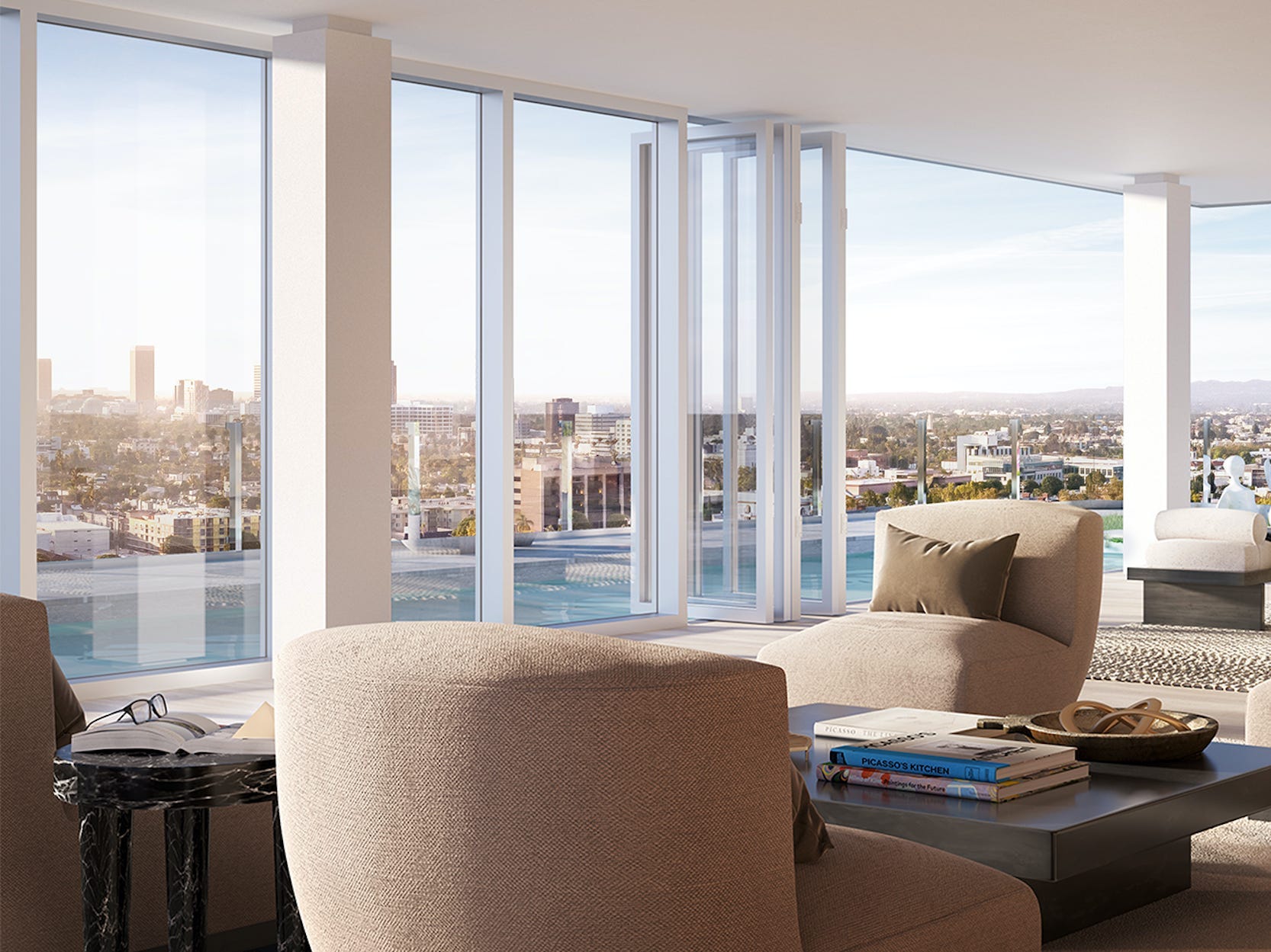 Gemeinschaftssitzgelegenheiten wie Sofas in einem Wohnzimmer mit eingezogenen Glastüren, die einen Blick auf Los Angeles freigeben.