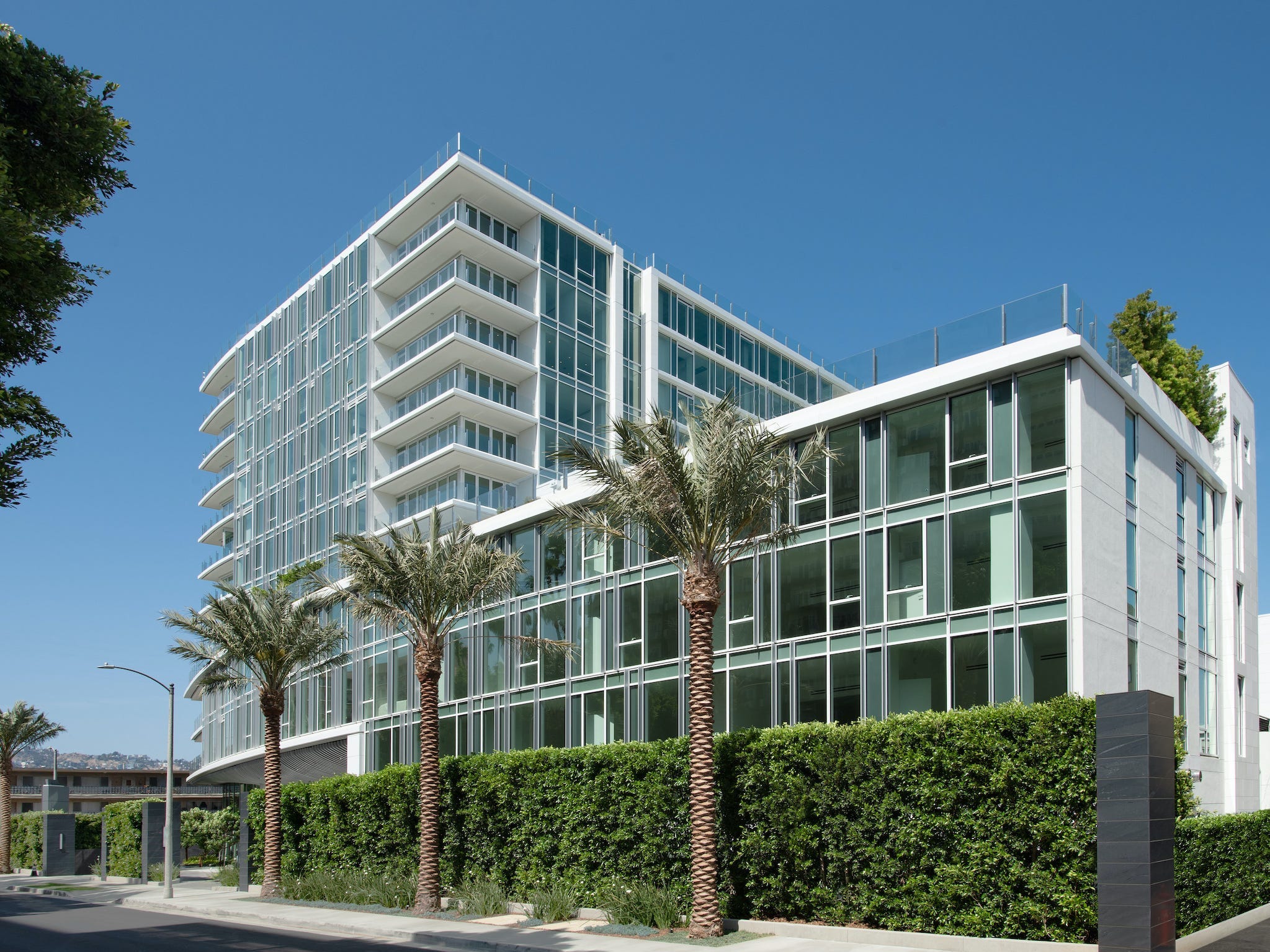 Das Äußere des Four Seasons Private Residences Los Angeles vor einem strahlend blauen Himmel.