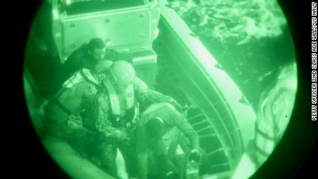 Die Besatzung der USCGC Glen Harris hilft geretteten Migranten beim Transfer von ihrem kleinen Boot zum Kutter im Atlantik.