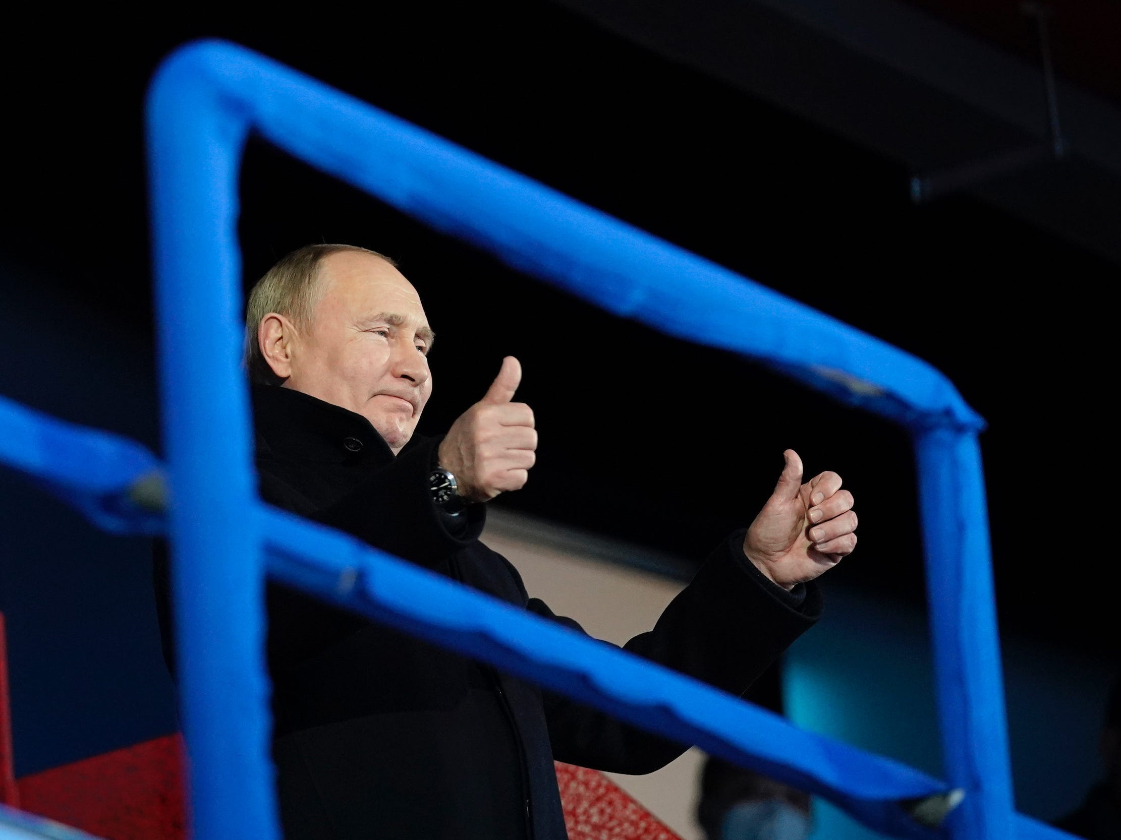 Der russische Präsident Wladimir Putin steht auf und gestikuliert, als die Athleten des russischen Olympischen Komitees zur diesjährigen Eröffnungsfeier eintreffen.