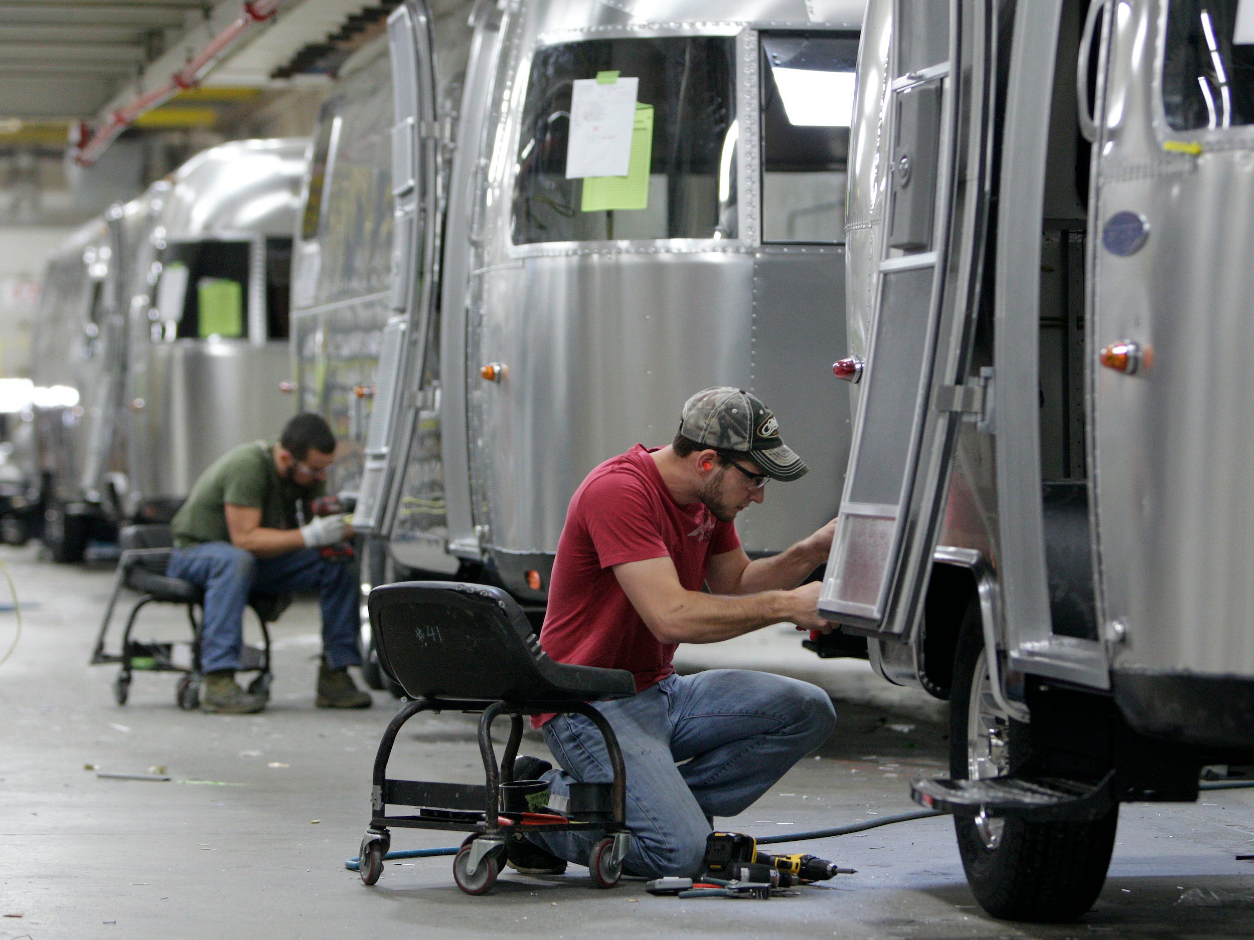 zwei Arbeiter, die 2014 in der Airstream-Fabrik an Airstream-Anhängern arbeiten
