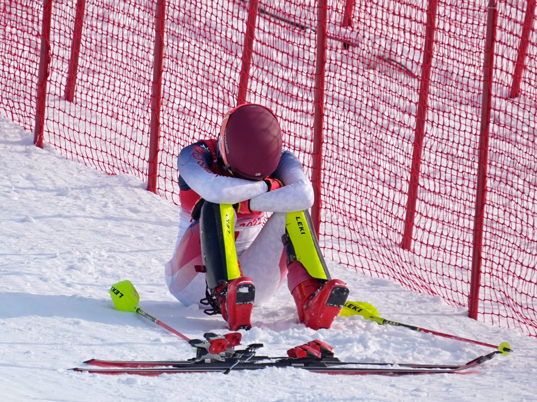 Mikaela Shiffrin sitzt mit dem Kopf in den Händen, nachdem sie bei den Olympischen Spielen im Slalom gestürzt ist.