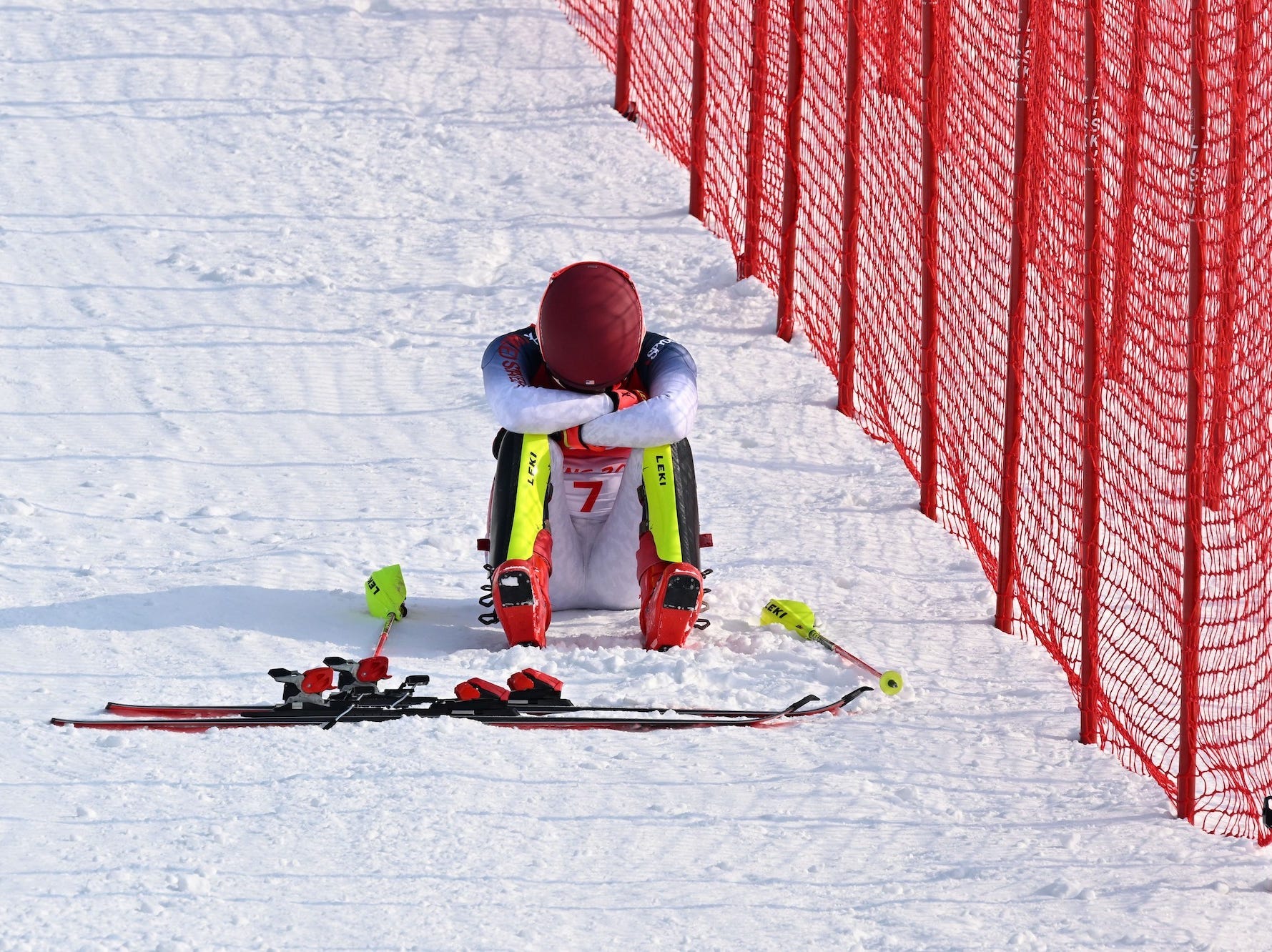 Mikaela Shiffrin sitzt bei den Olympischen Spielen in Peking mit dem Kopf in den Händen im Schnee.