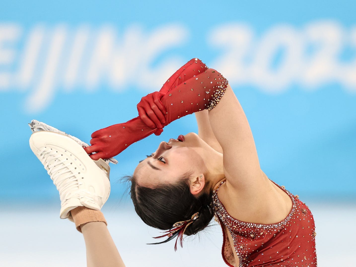 Die Chinesin Zhu Yi bringt während des Eiskunstlaufwettbewerbs bei den Olympischen Spielen in Peking ihren Fuß an den Hinterkopf.