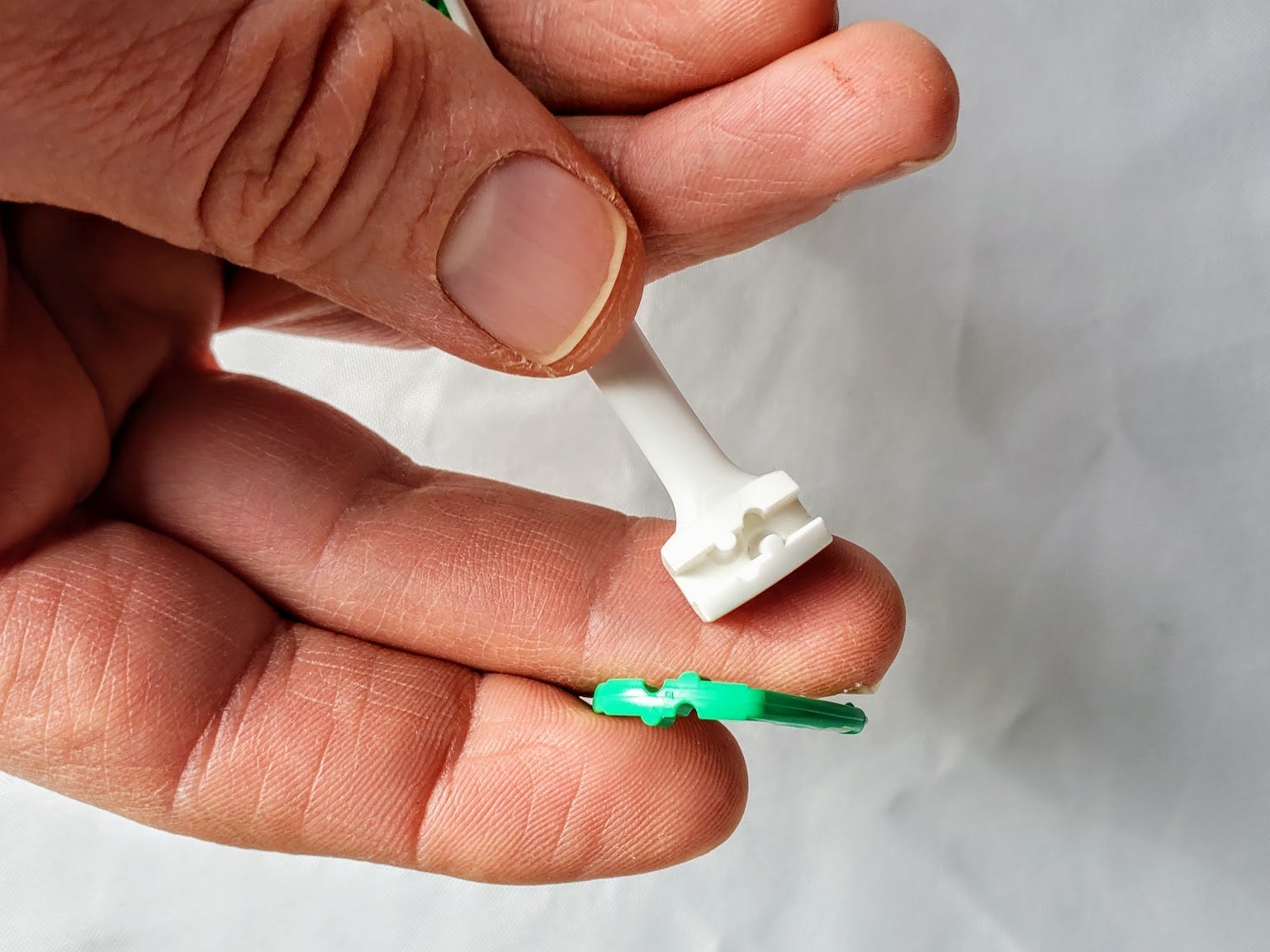 Der entfernte Kopf der ultrareinen Zahnseide von Listerine zeigt, wo er eingesetzt wird, Rückblick 2022