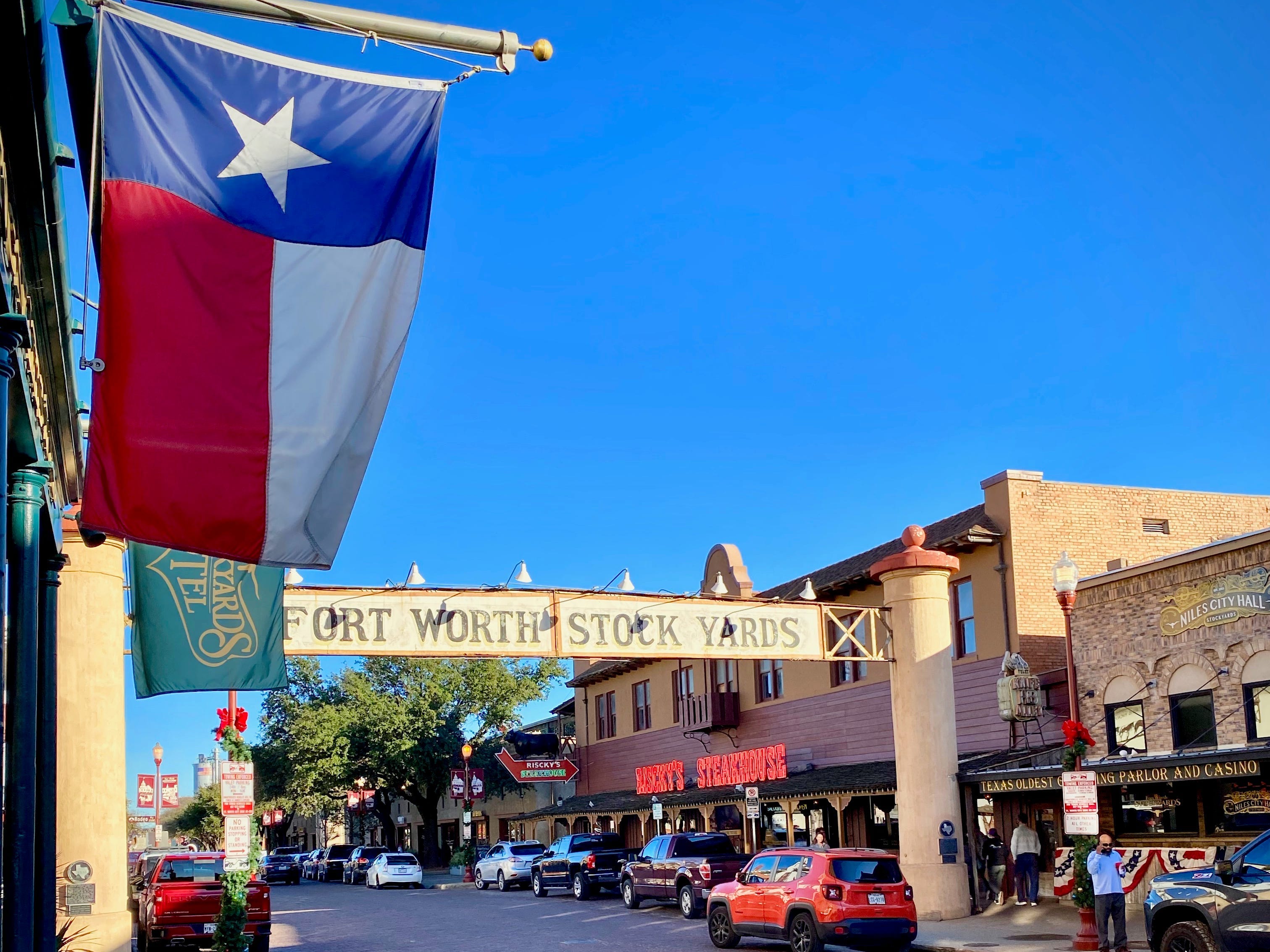 Die texanische Flagge hängt an einem Geschäft auf einer gepflasterten Straße, die von Geschäften gesäumt ist.