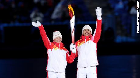 Die Fackelträger Dinigeer Yilamujiang und Jiawen Zhao vom Team China halten das olympische Feuer während der Eröffnungszeremonie am 4. Februar.