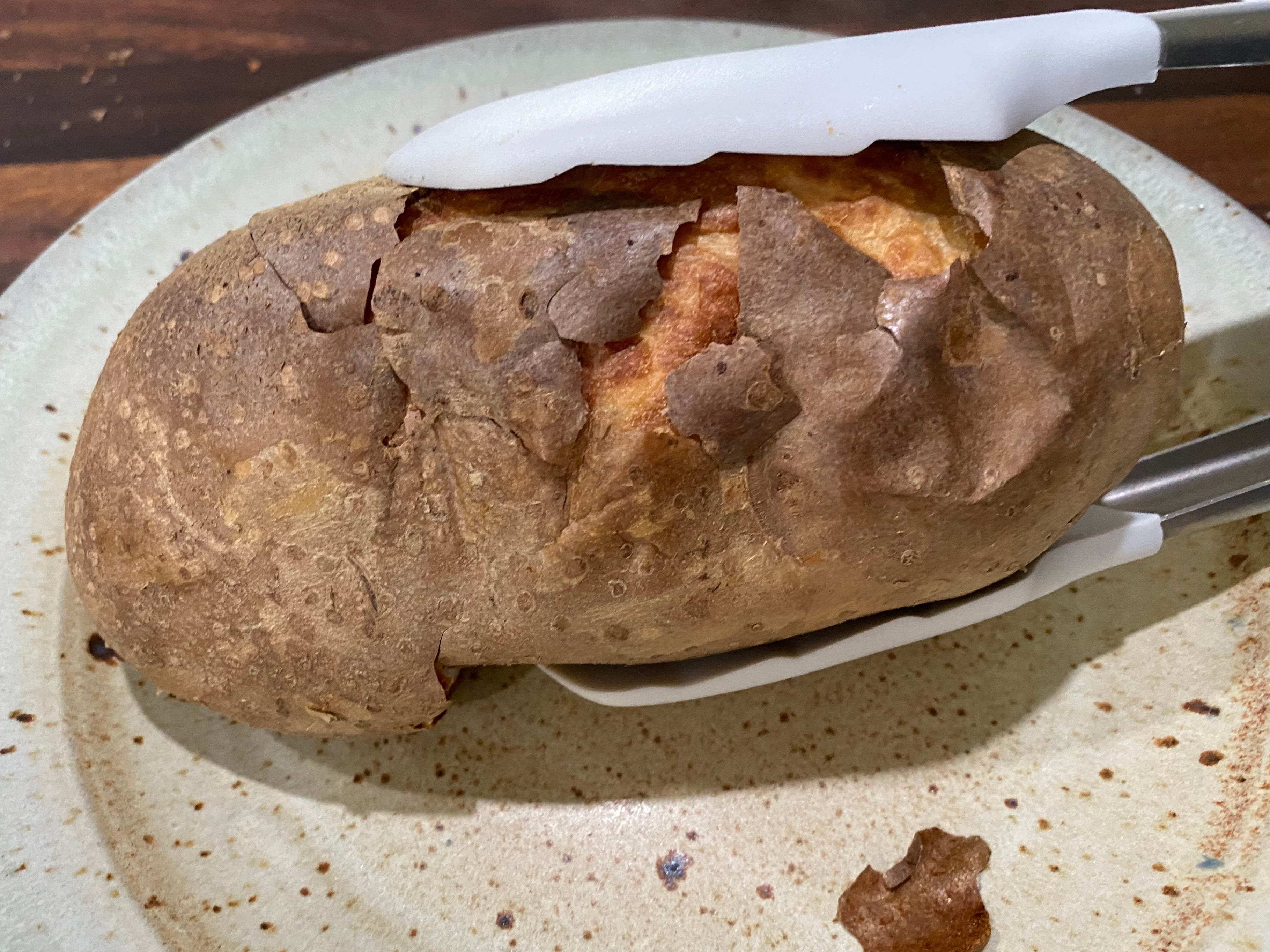 Super knusprige Kartoffel mit einer Zange halten