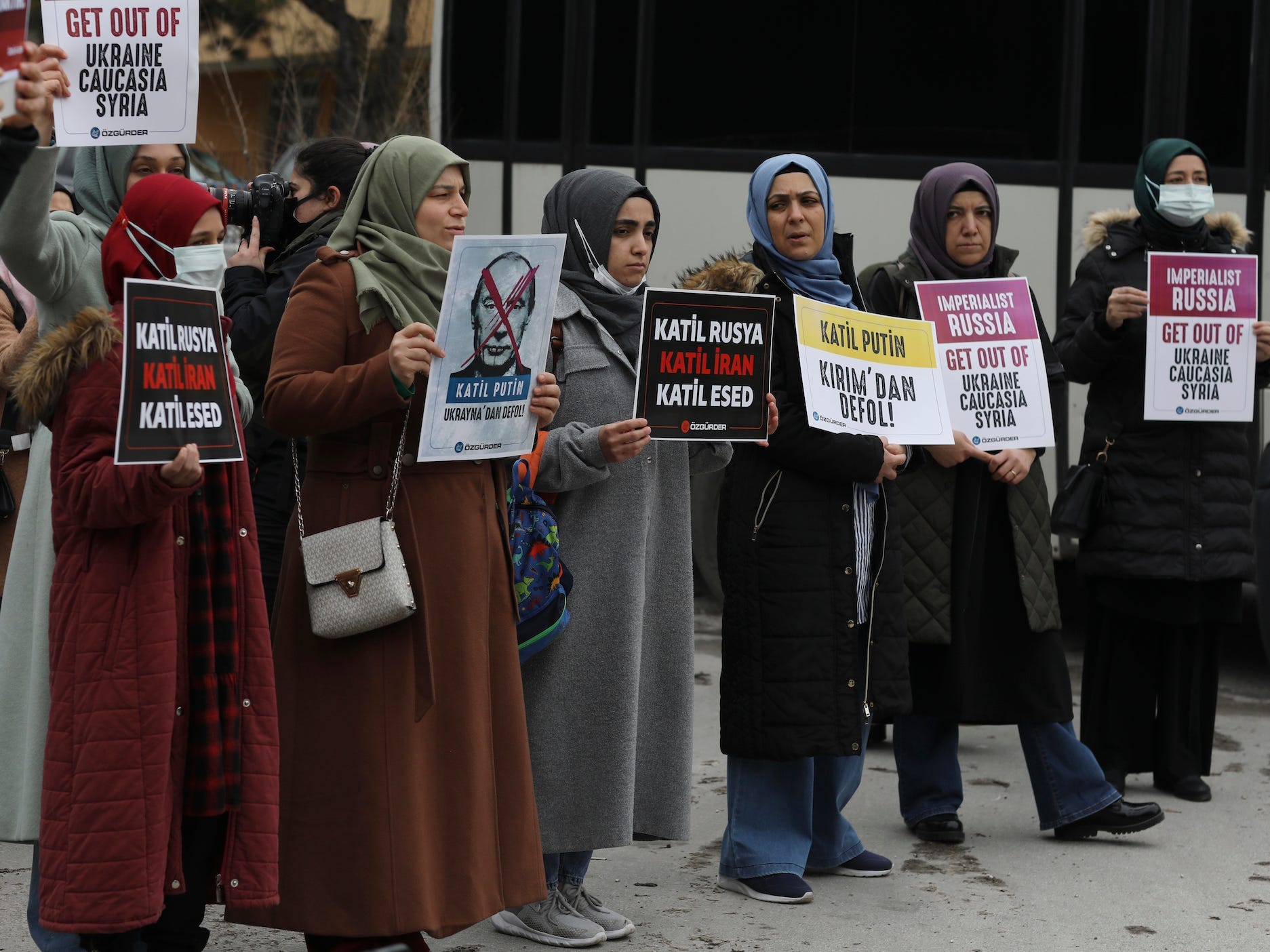 Frauen halten Plakate, als Mitglieder einer regierungstreuen Menschenrechtsgruppe vor der russischen Botschaft in Ankara, Türkei, am Samstag, 26. Februar 2022, gegen die russische Invasion in der Ukraine protestieren.