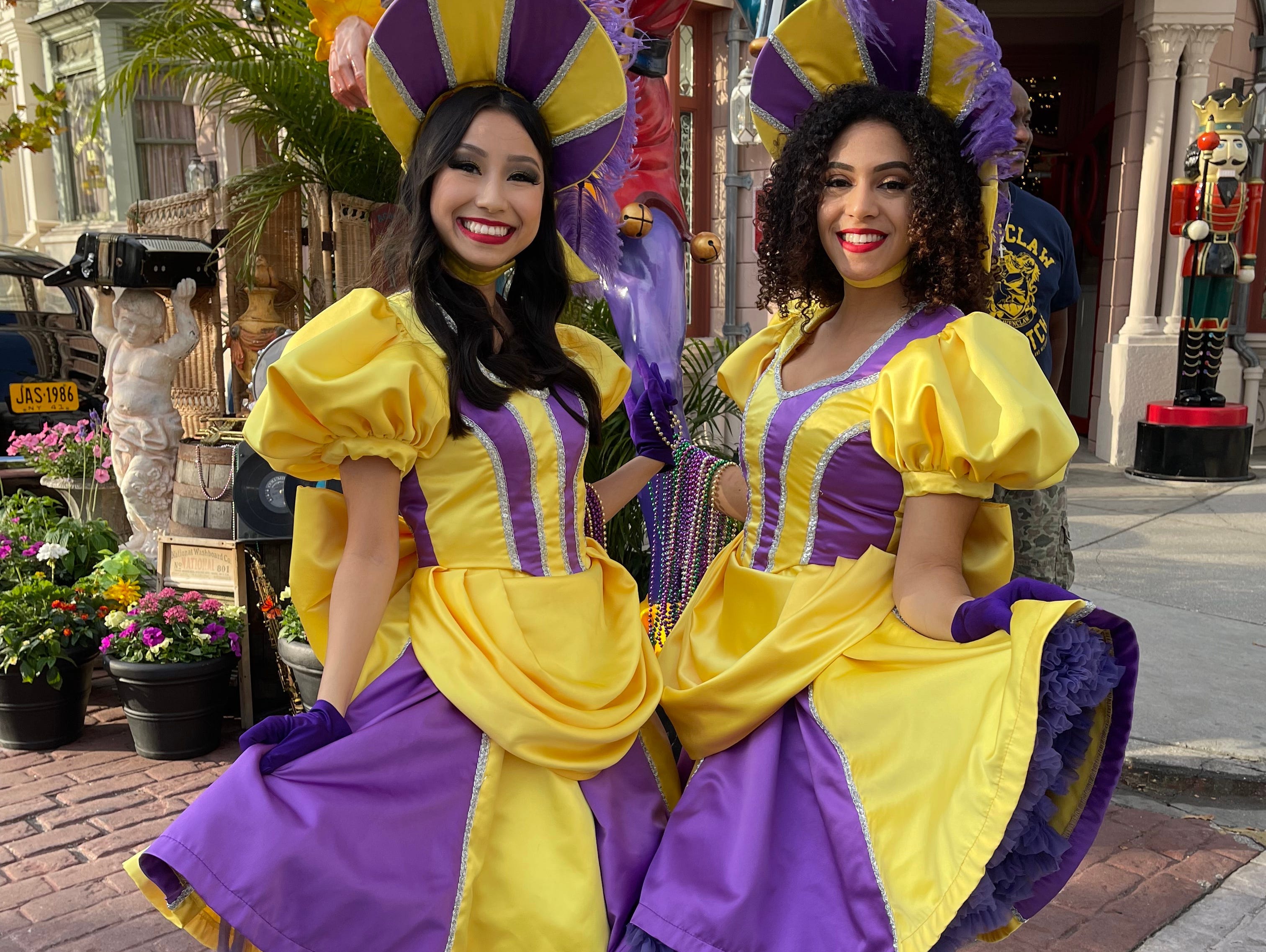 Zwei Darsteller in lila und gelben Kleidern und Hüten beim Universal Orlando Mardi Gras