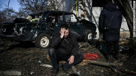 Ein Mann sitzt vor seinem zerstörten Gebäude nach Bombenanschlägen auf die ostukrainische Stadt Tschuguiw am 24. Februar 2022.
