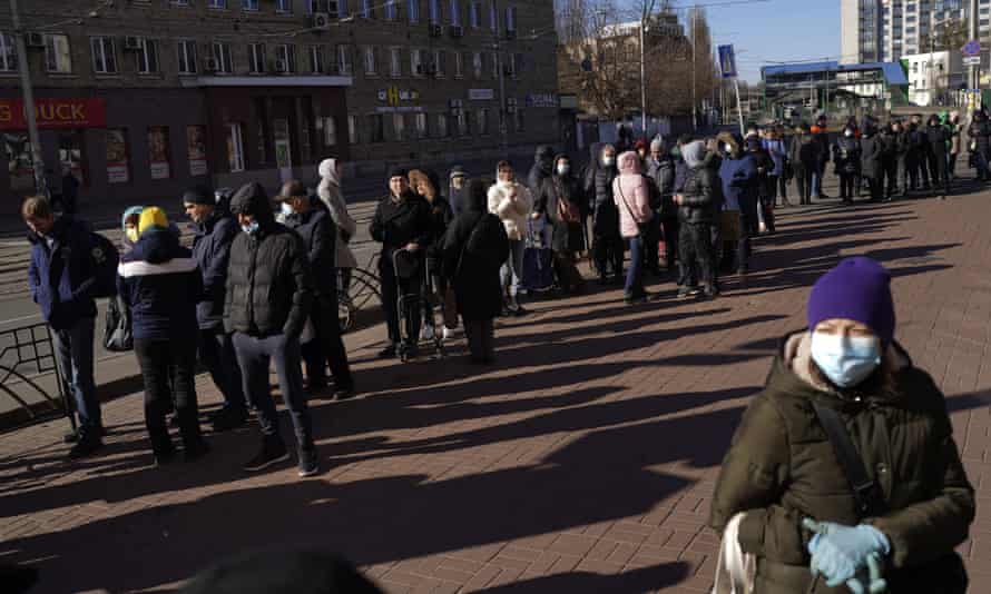 Menschen warten in einer Schlange vor einem Supermarkt im Zentrum von Kiew, Ukraine.
