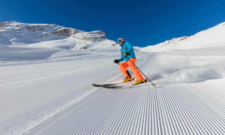 Junger Mann beim Skifahren in den Alpen.  Schöner klarer blauer Himmel.  Wintersport und Erholung.