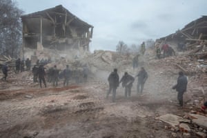 Menschen beseitigen Trümmer auf dem Gelände einer Militärbasis in Okhtyrka.