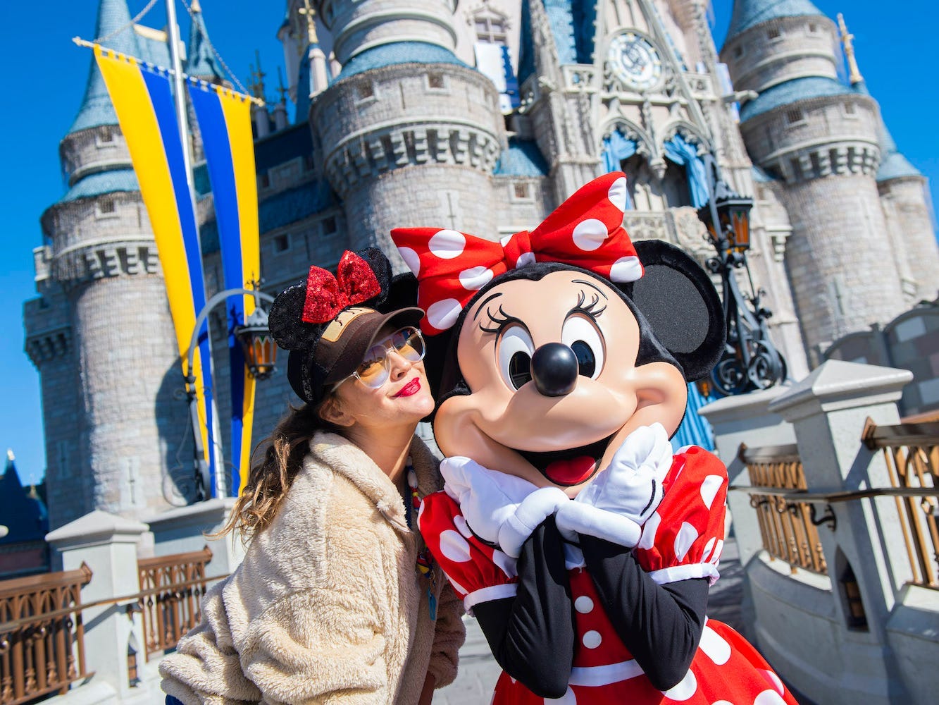 Drew Barrymore posiert mit Minnie Mouse, während er mit der Familie im Magic Kingdom Park im Walt Disney World Resort Urlaub macht.