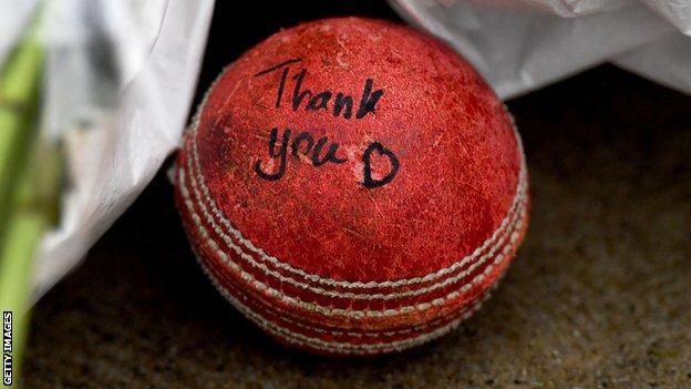 Ein Cricketball hinter Shane Warnes Statue im MCG