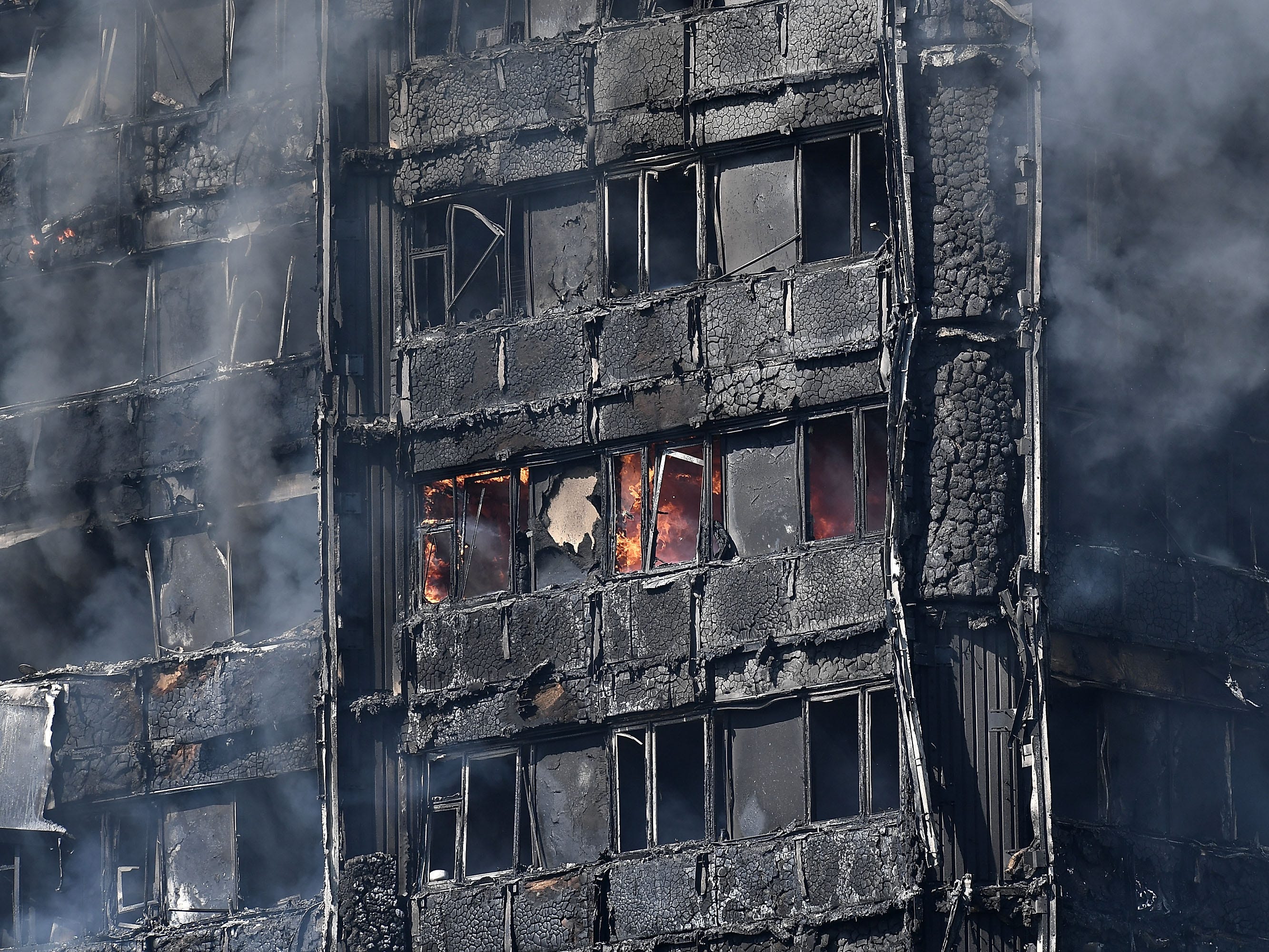 Rauch steigt aus dem brennenden 24-stöckigen Wohnblock Grenfell in der Latimer Road, West London am 14. Juni 2017 in London, England.