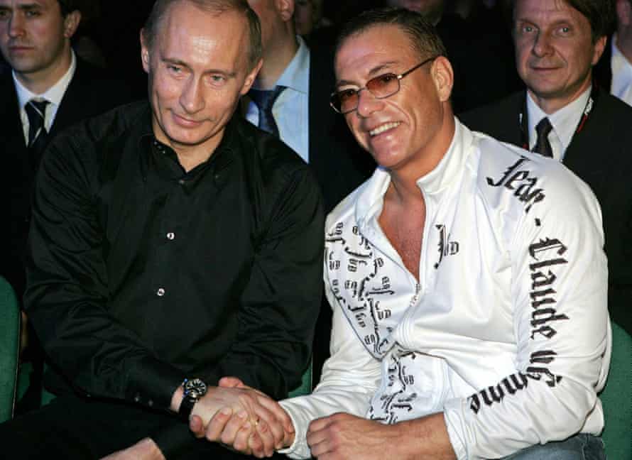 Putin schüttelt dem Martial-Arts-Filmstar Jean-Claude Van Damme die Hand, als sie sich 2007 in St. Petersburg ein gemischtes Kampfereignis ansehen.