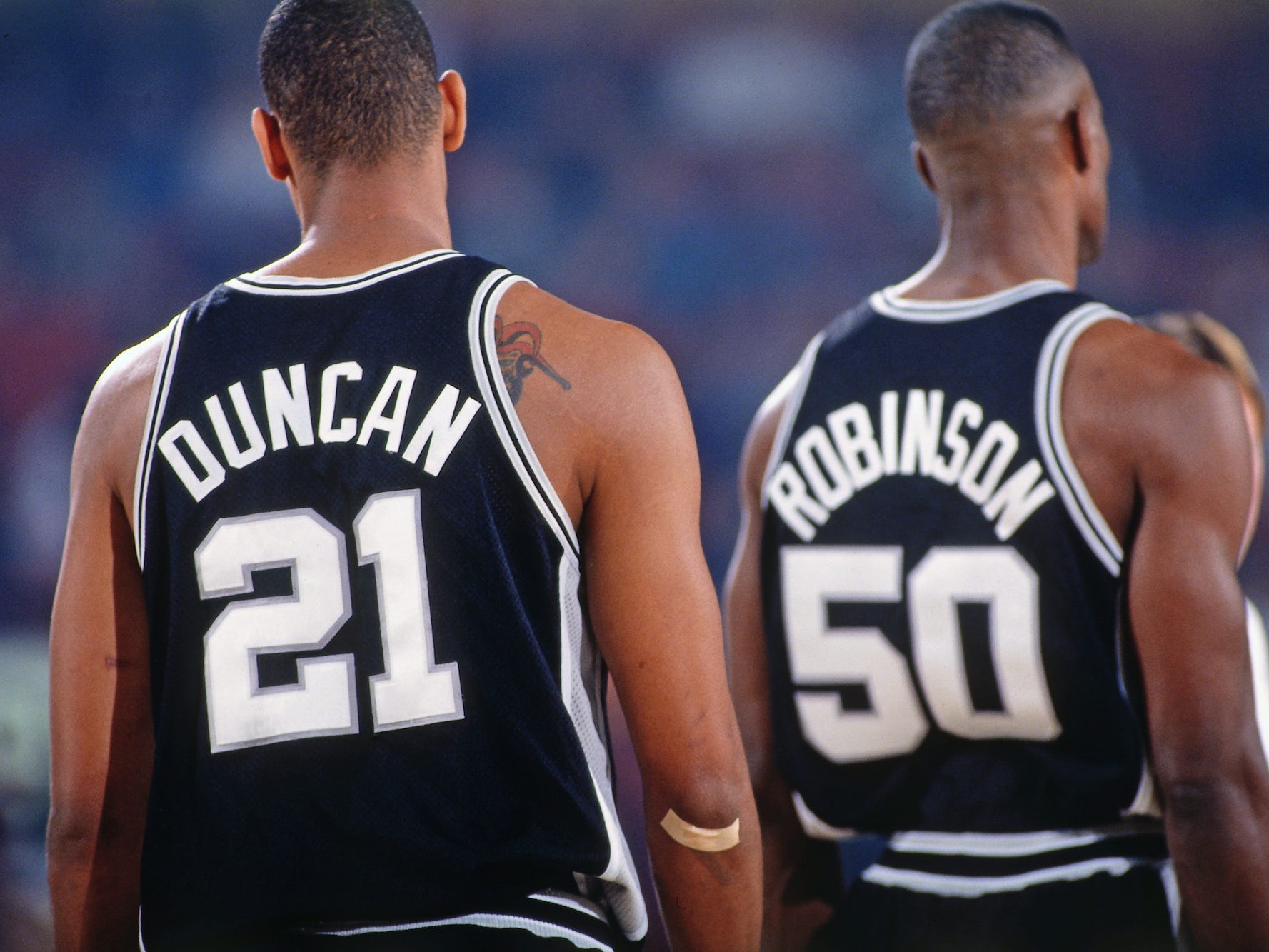 Tim Duncan und David Robinson stehen 1997 während eines Spiels mit dem Rücken zur Kamera.