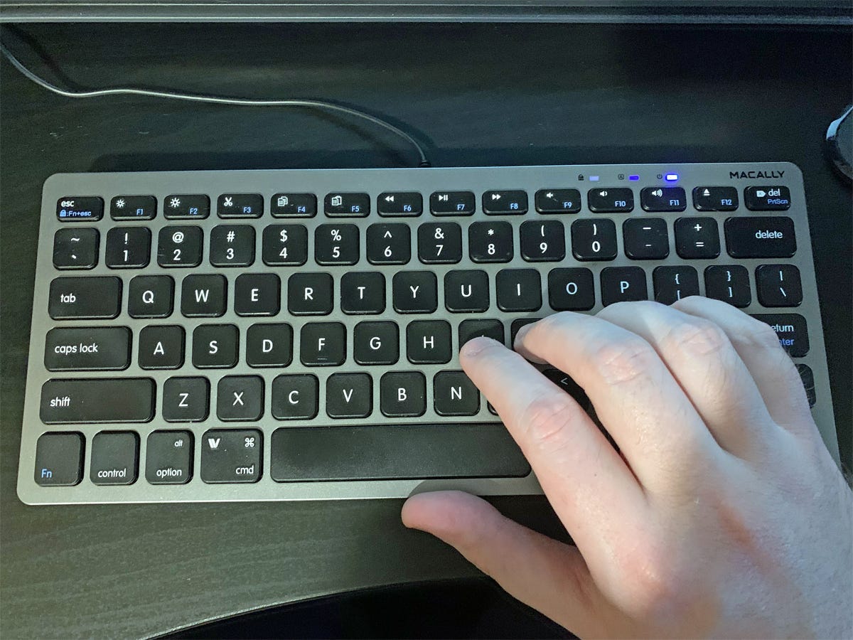 Eine Hand, die auf der Macally Small USB Wired Keyboard tippt