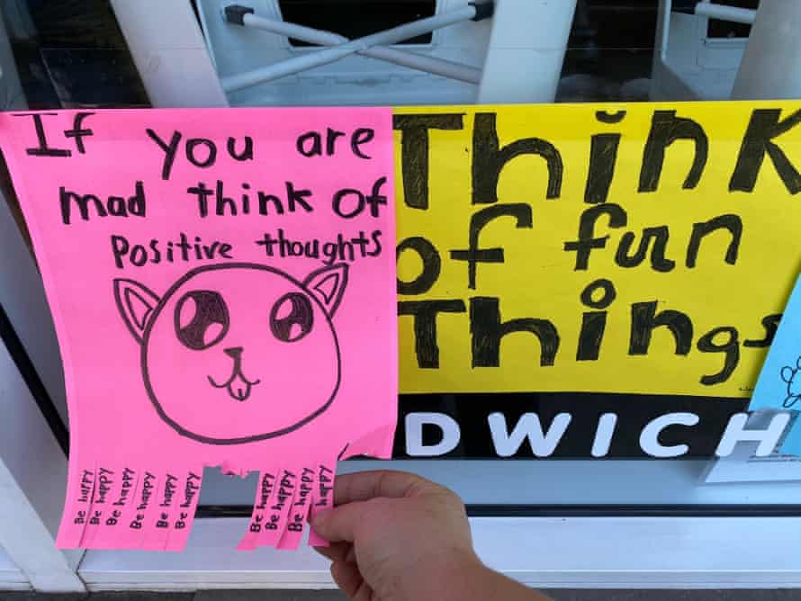 Auf einem rosa Poster steht „Wenn du verrückt bist, denk an positive Gedanken“ über einer Zeichnung einer Katze.  Auf dem gelben Plakat daneben steht „Think of fun things“.