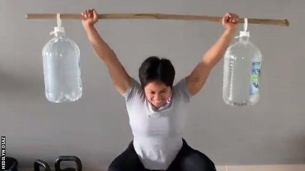 Hidilyn Diaz hebt behelfsmäßige Gewichte aus Bambusstöcken und Wasserflaschen.