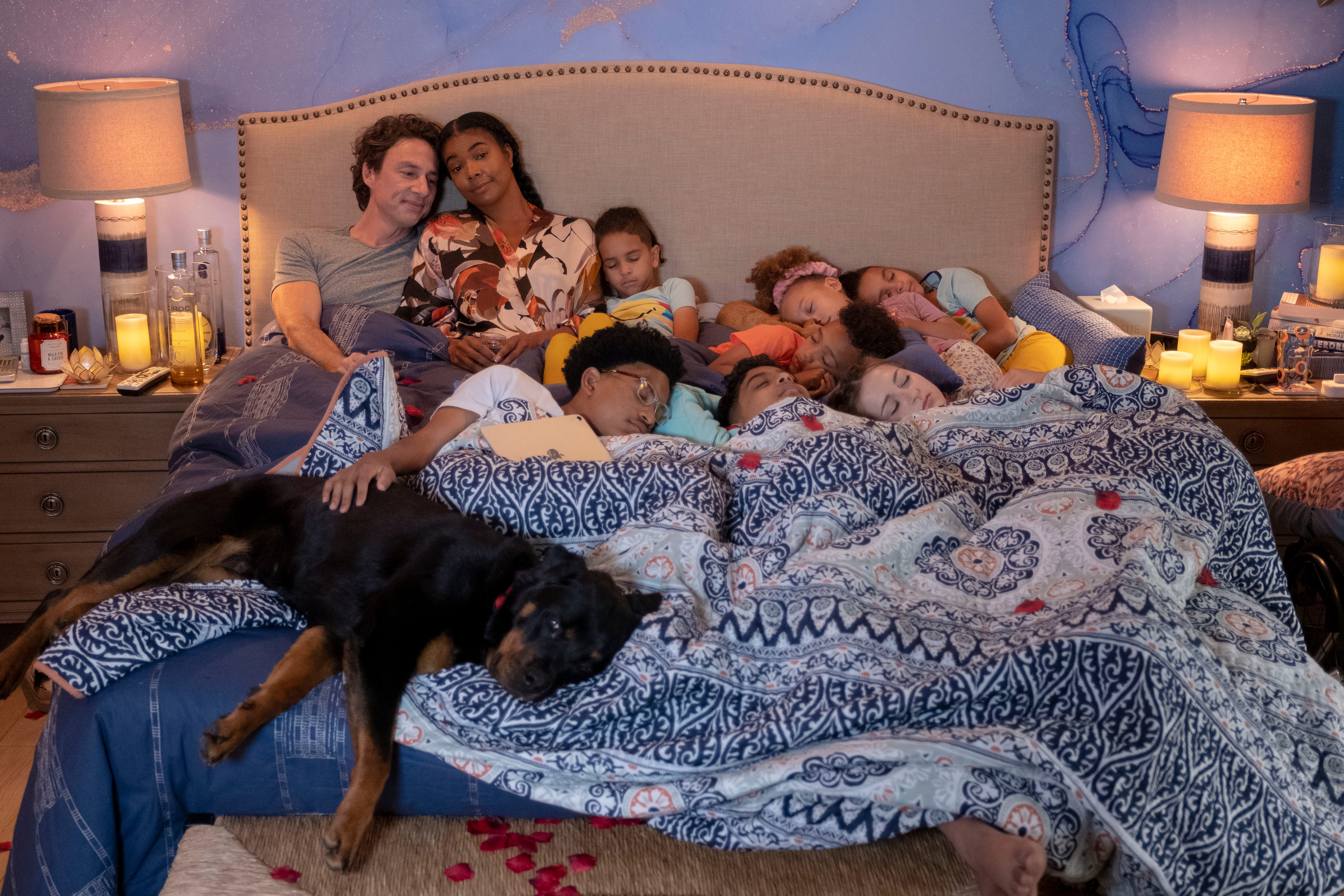 Zach Braff und Gabrielle Union mit vielen Kindern und einem Hund in einem Bett