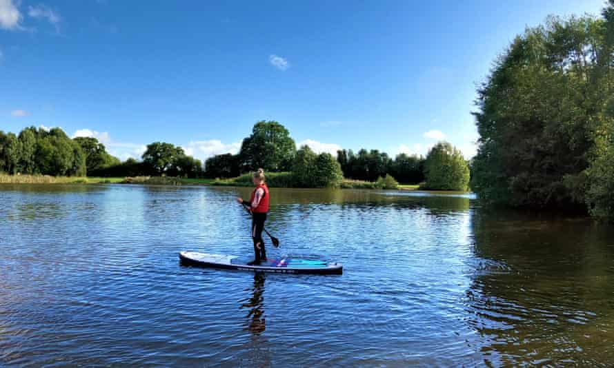 Eine Frau paddelt auf dem Alderford Lake