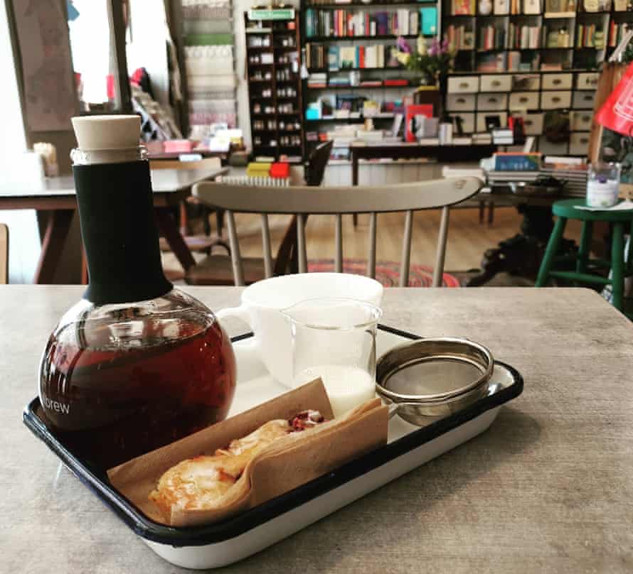 Ein Fläschchen Kaffee und Gebäck, im Hintergrund Bücherregale