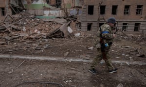 Ein ukrainischer Soldat geht an einem zerstörten Gebäude in der Stadt Okhtyrka in der Region Sumy vorbei.