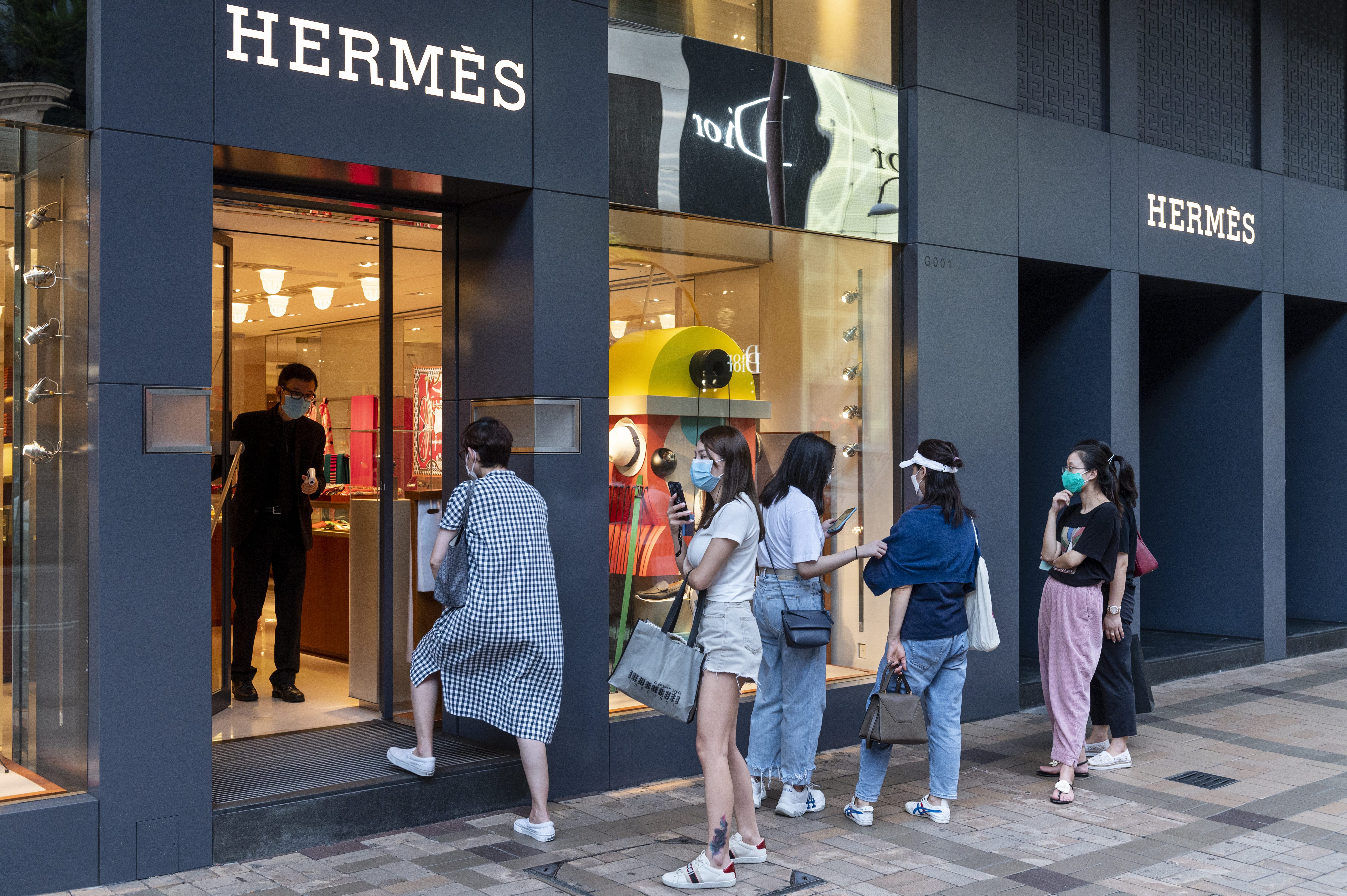 Kunden stehen Schlange vor einem Hermes-Geschäft