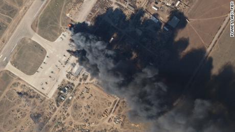 Ein Satellitenbild zeigt eine große schwarze Rauchwolke, die am Dienstag, dem 15. März, vom Kherson International Airport aufsteigt. Beim Vergrößern zeigen die Satellitenbilder, dass eine Reihe von Hubschraubern in Flammen stehen.