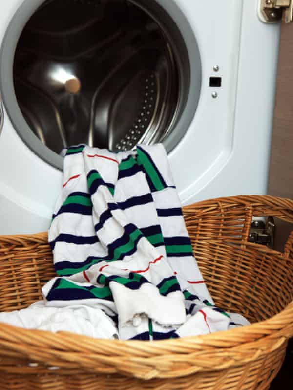 Saubere Wäsche, die aus einer Waschmaschine in einen Korb kommt