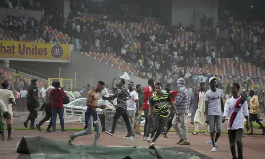 Die Polizei setzt Tränengas ein, um zu versuchen, nigerianische Zuschauer vom Spielfeld zu entfernen, nachdem sich Ghana auf Kosten Nigerias aufgrund von Auswärtstoren qualifiziert hatte.