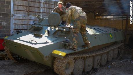 Soldaten der ukrainischen Territorialverteidigungskräfte inspizieren einen russischen Schützenpanzer, den sie auf dem Schlachtfeld erbeutet haben.