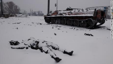 Schnee bedeckt den Körper eines toten russischen Soldaten in der Nähe einer Autobahn außerhalb von Charkiw, Ukraine, einen Tag nach Beginn der Invasion. 